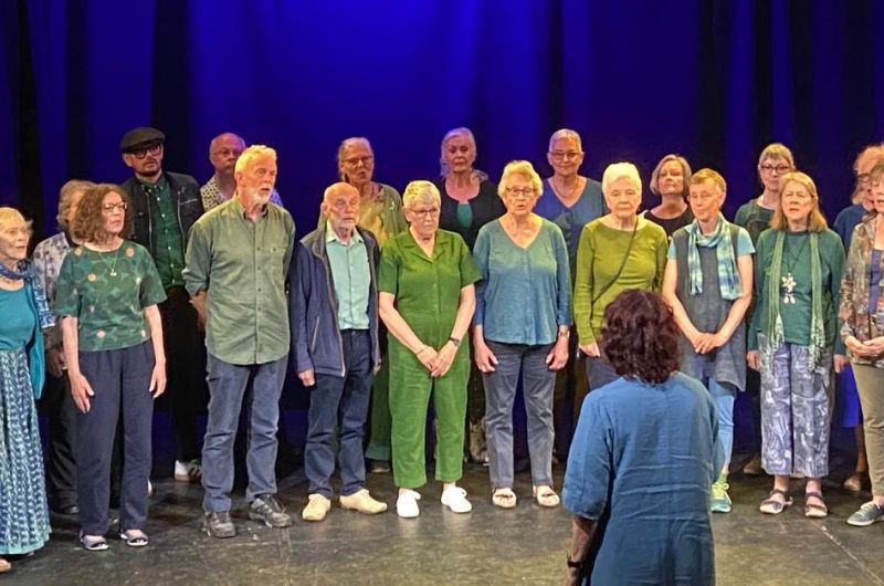 A photo of a group of people standing in a semi-circle on a stage